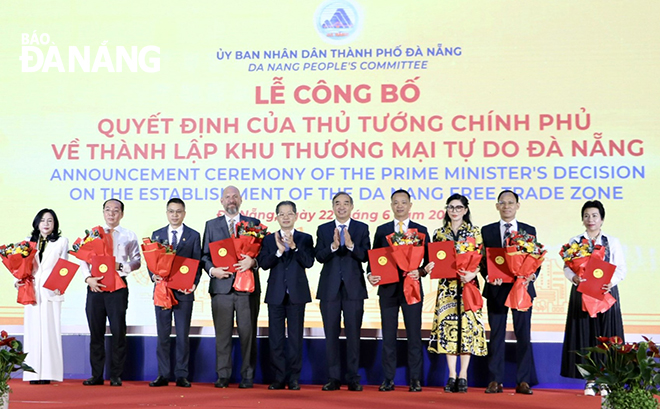 Lãnh đạo thành phố (giữa) trao biên bản ghi nhớ hợp tác giữa UBND thành phố với các nhà đầu tư về phát triển Khu thương mại tự do Đà Nẵng. Ảnh: M.QUẾ