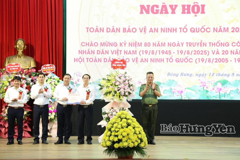Thiếu tướng Trần Xuân Ánh, Ủy viên Ban Thường vụ Tỉnh ủy, Giám đốc Công an tỉnh tặng hoa và quà chúc mừng ngày hội toàn dân bảo vệ an ninh Tổ quốc tại xã Đông Hưng.