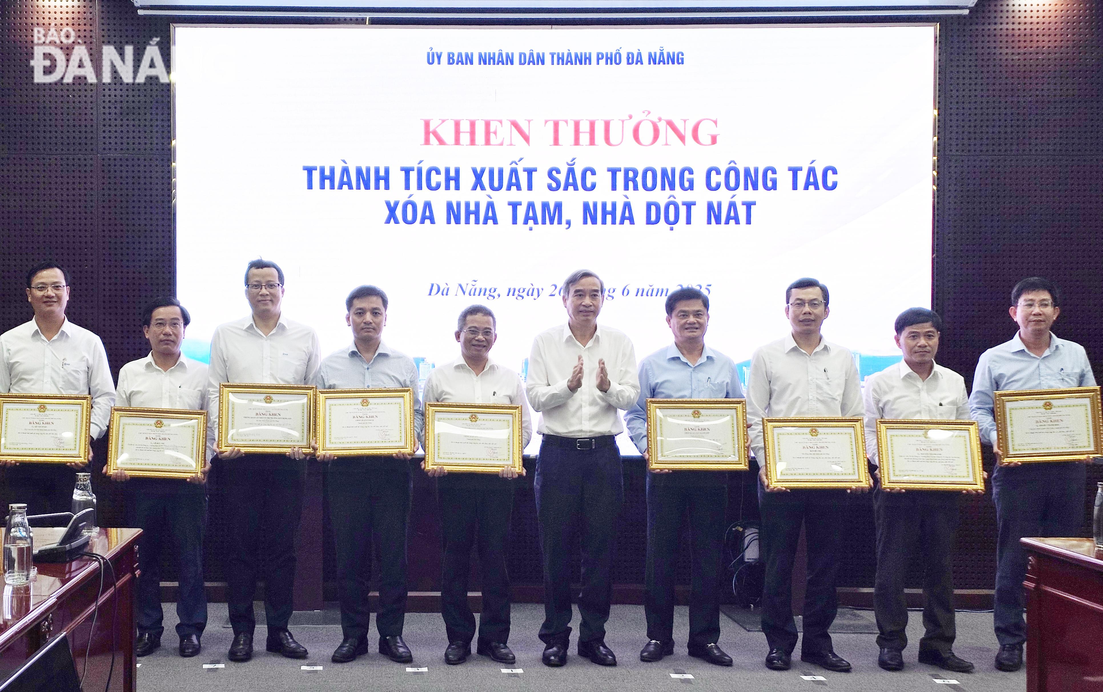 Chủ tịch UBND thành phố Lê Trung Chinh () trao bằng khen cho các tập thể, cá nhân có thành tích xuất sắc trong công tác xóa nhà tạm, nhà dột nát. Ảnh: LAM PHƯƠNG