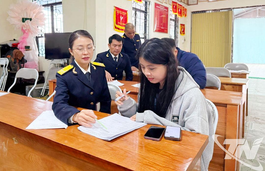 Cán bộ thuế hướng dẫn người dân đăng ký chuyển đổi từ thuế khoán sang tự kê khai tại phường Bắc Kạn.