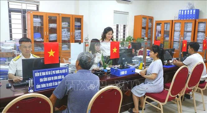 Hỗ trợ giải quyết thủ tục hành chính tại bộ phận 1 cửa cơ quan Thuế đầu tháng 7/2025. Ảnh: TTXVN phát
