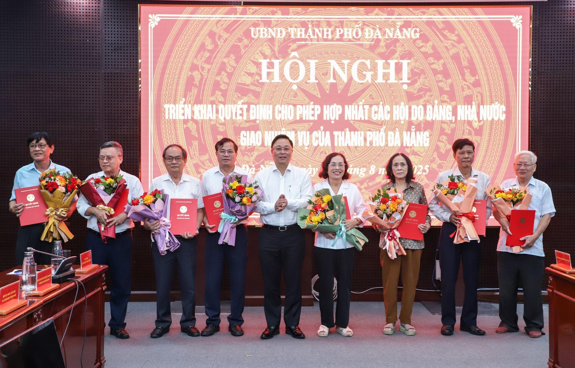 Chủ tịch Ủy ban MTTQ Việt Nam thành phố Lê Trí Thanh (giữa) trao quyết định hợp nhất các hội do Đảng, Nhà nước giao nhiệm vụ trên địa bàn thành phố. Ảnh: NGỌC PHÚ