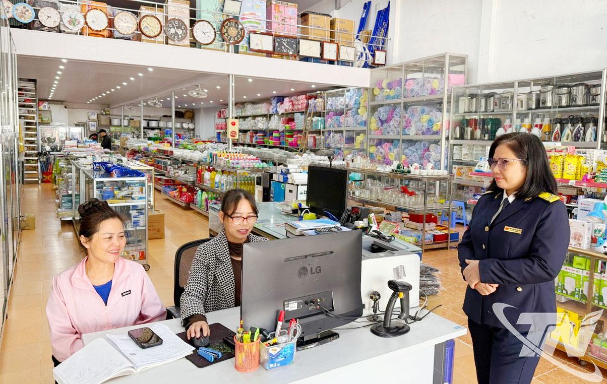 Cán bộ Thuế cơ sở 6 hỗ trợ người nộp thuế tại cơ sở kinh doanh.