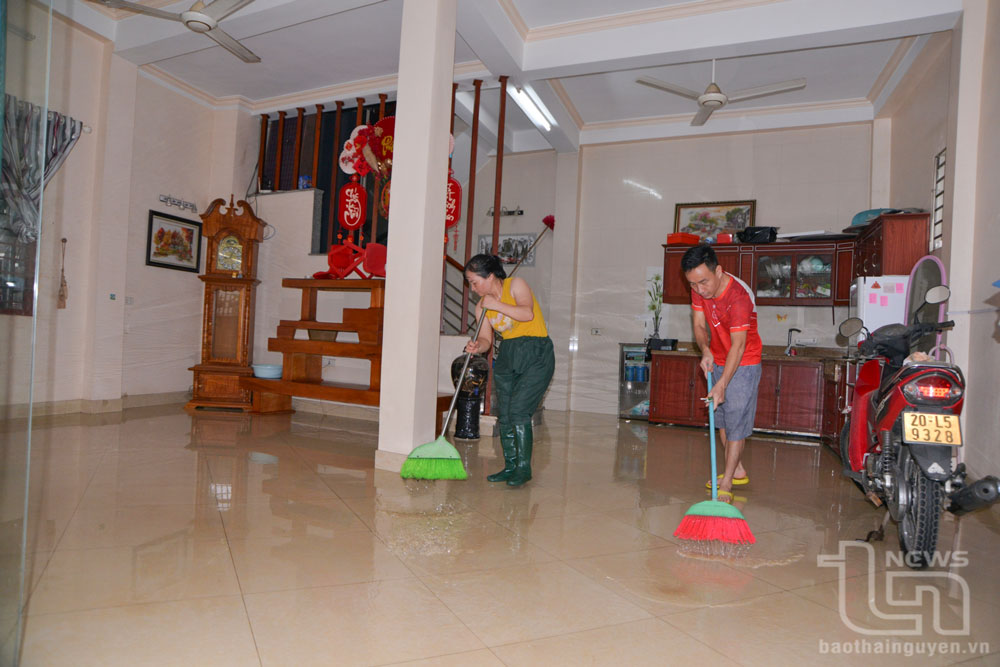 Các hộ dân ở tổ dân phố 11, phường Túc Duyên (TP. Thái Nguyên) tranh thủ lúc nước đang rút dần, đẩy bùn đất ra ngoài, vệ sinh nhà cửa.