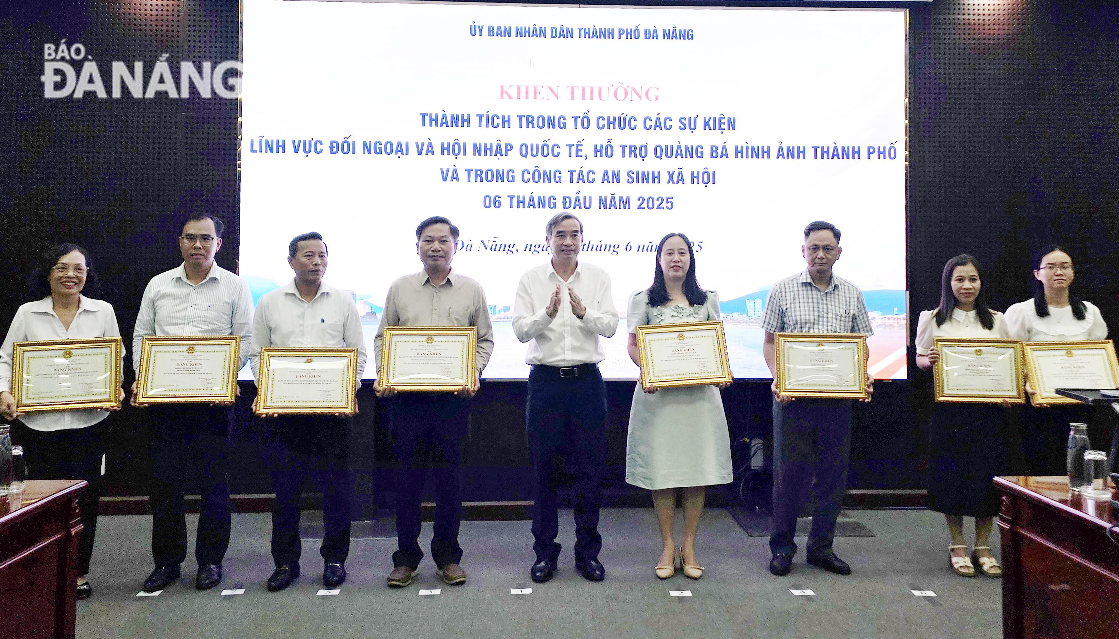 Chủ tịch UBND thành phố Lê Trung Chinh () trao bằng khen cho các tập thể, cá nhân có thành tích trong thực hiện nhiệm vụ 6 tháng đầu năm 2025. Ảnh: LAM PHƯƠNG