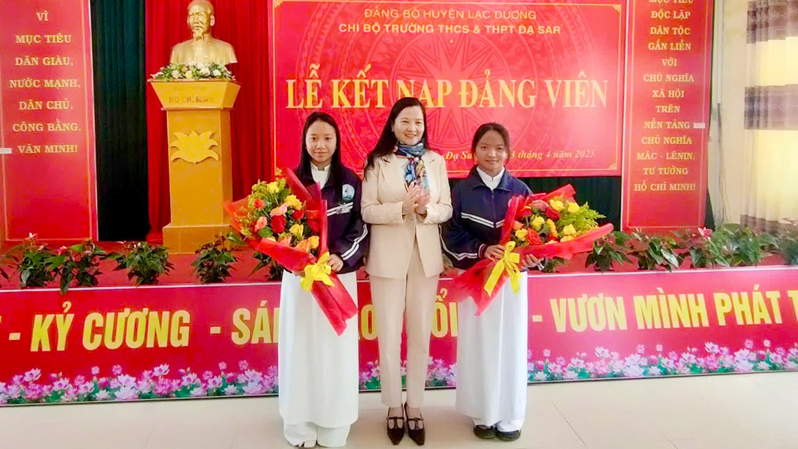Đồng chí Trần Thị Chúc Quỳnh - Bí thư Huyện ủy Lạc Dương tặng hoa chúc mừng 2 học sinh của Trường THCS&THPT Đạ Sar vừa được kết nạp Đảng