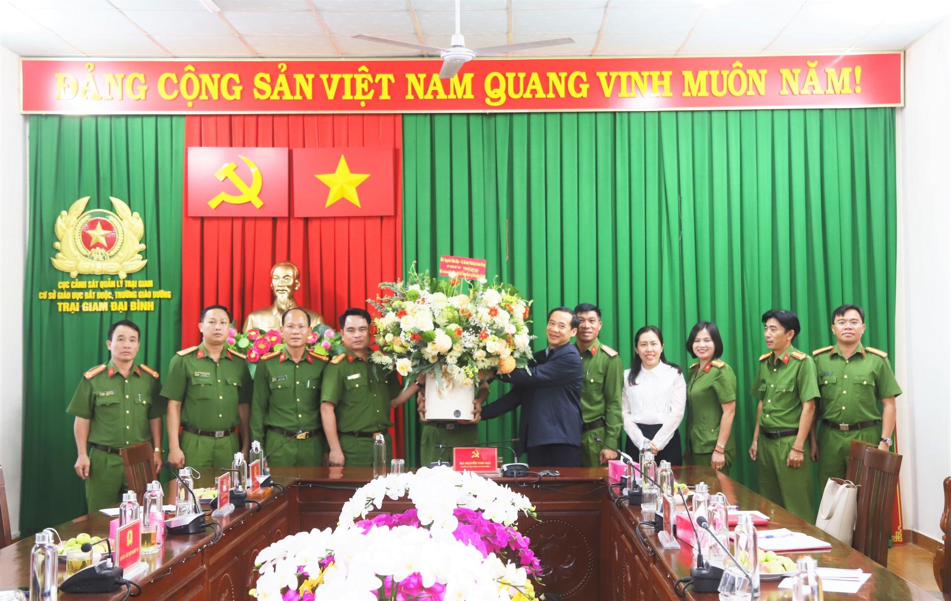 Đồng chí Nguyễn Thái Học - Quyền Bí thư Tỉnh ủy Lâm Đồng tặng hoa chúc mừng tập thể lãnh đạo, cán bộ, chiến sĩ Trại giam Đại Bình nhân kỷ niệm 50 năm thành lập Trại
