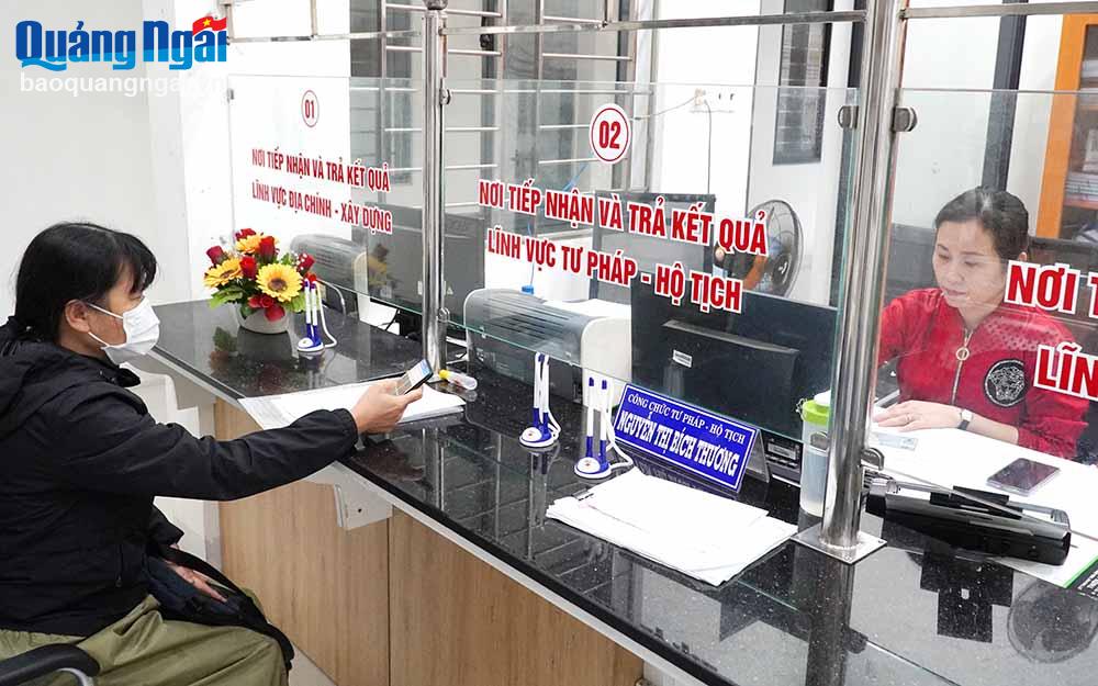Cán bộ bộ phận một cửa thị trấn Sông Vệ (Tư Nghĩa) giải quyết thủ tục hành chính cho người dân.                      Ảnh: TL